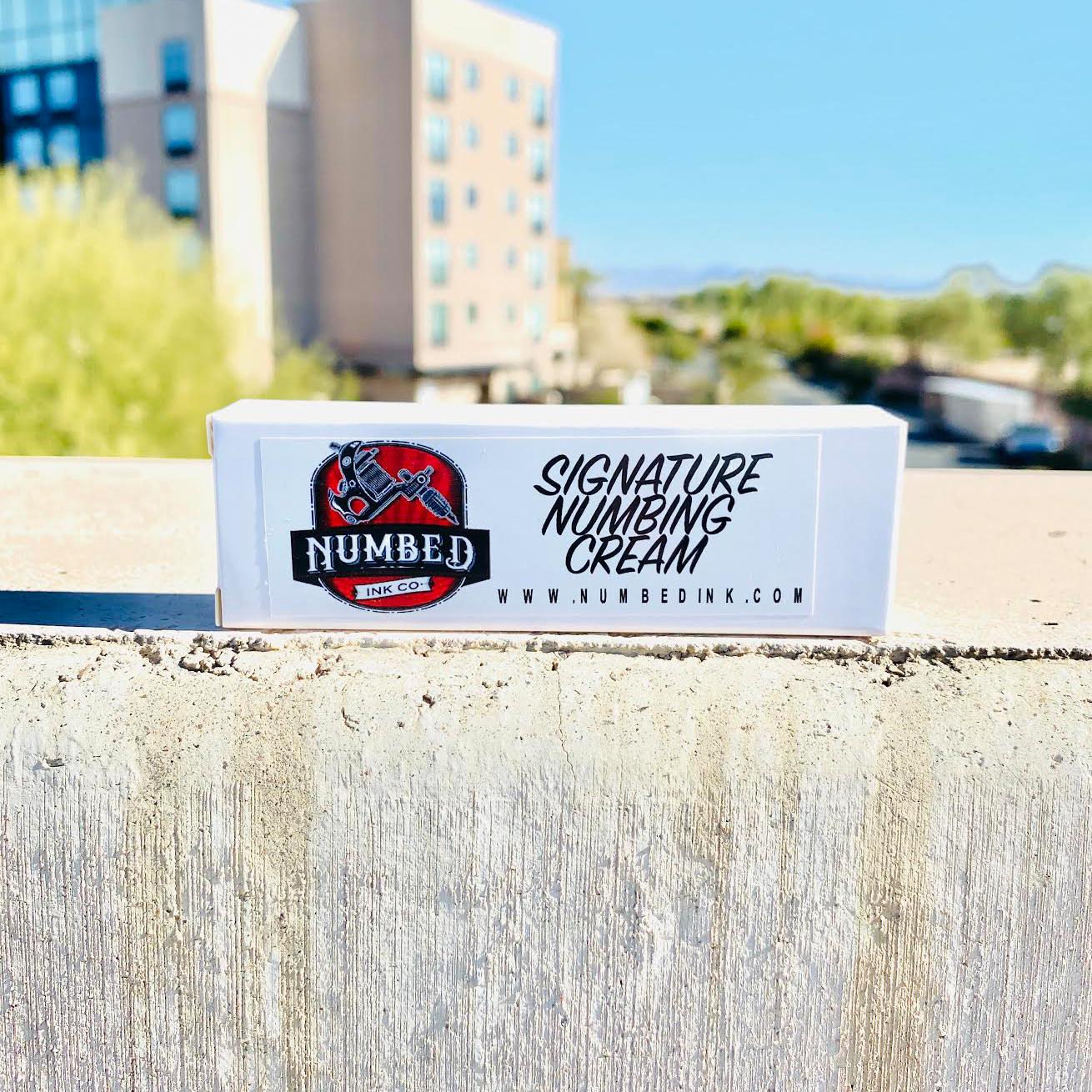 Box of Signature Numbing Cream on a wall.